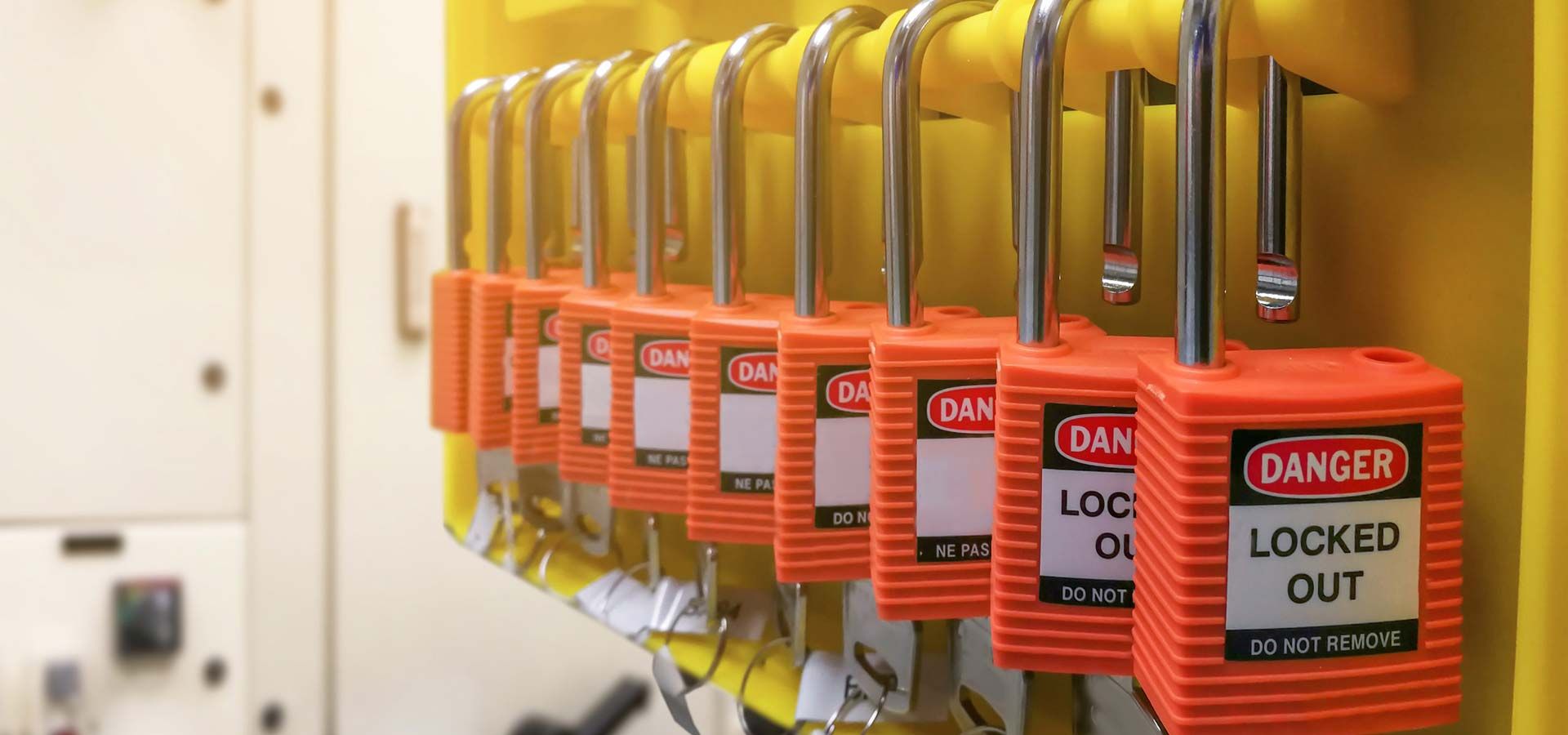 Elektrik panosunun önündeki rayda sıra sıra asılı kırmızı ve sarı emniyet asma kilitleri